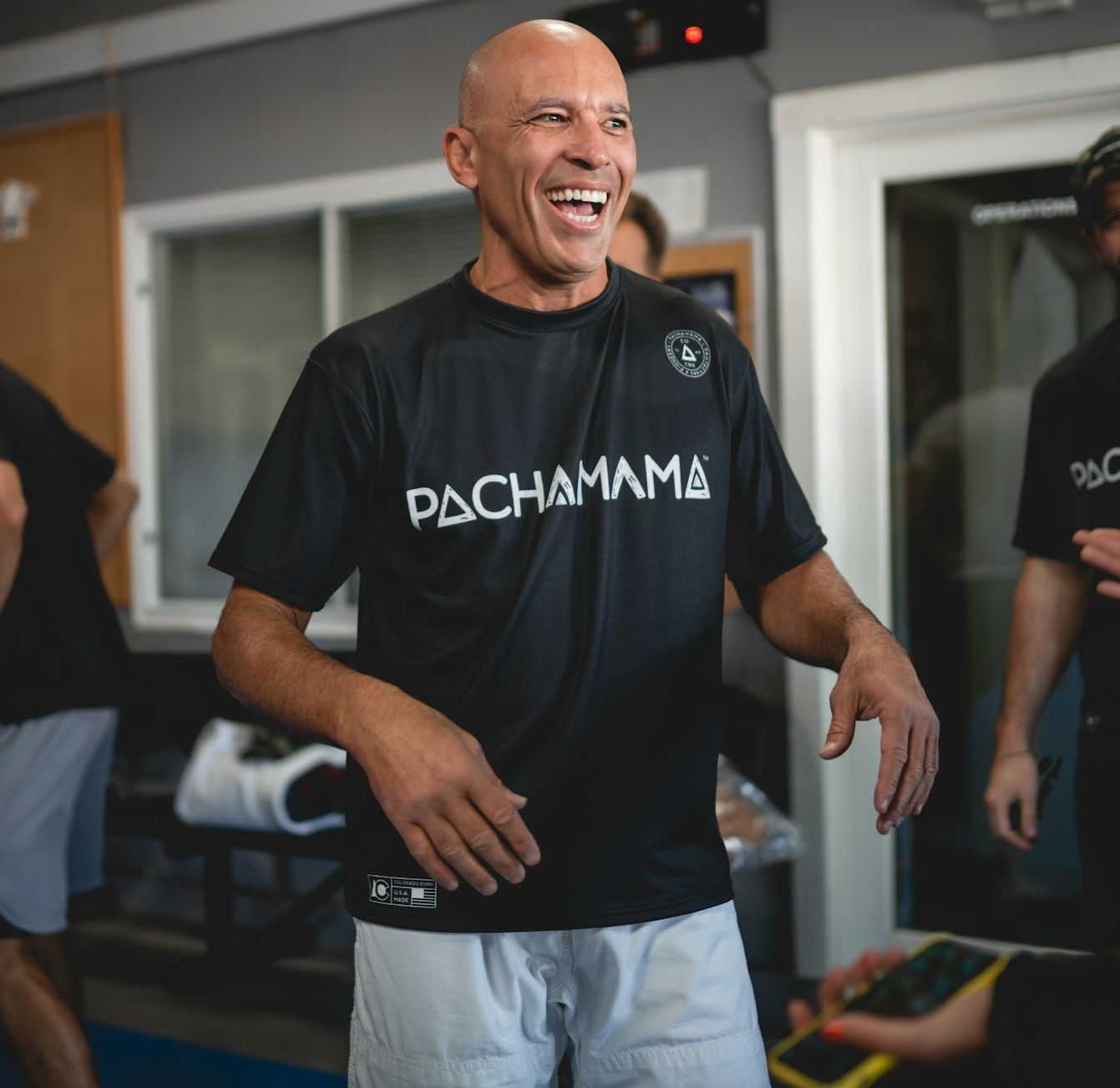 Close-up of a grappler's hands being taped for finger protection, moody lighting, focused on texture of the athletic tape